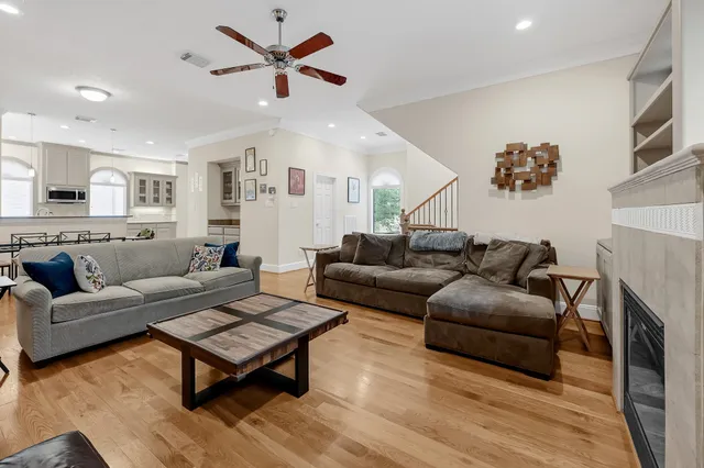 a living room with furniture a ceiling fan and a fireplace