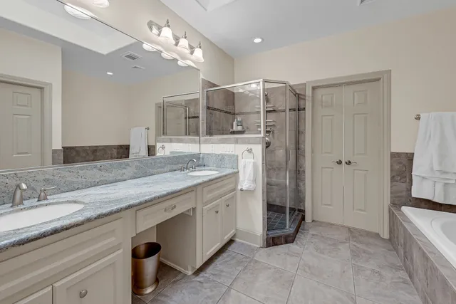 a bathroom with a granite countertop sink a bathtub and shower