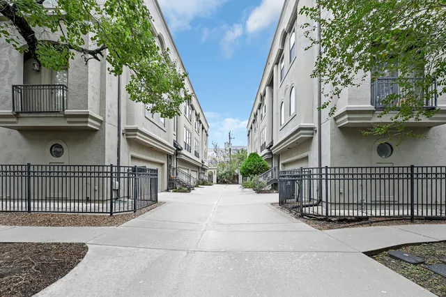 a view of a street with brick wall and potted plants