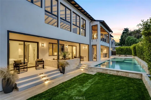 a view of a house with swimming pool and sitting area