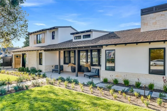 a front view of a house with swimming pool and furniture