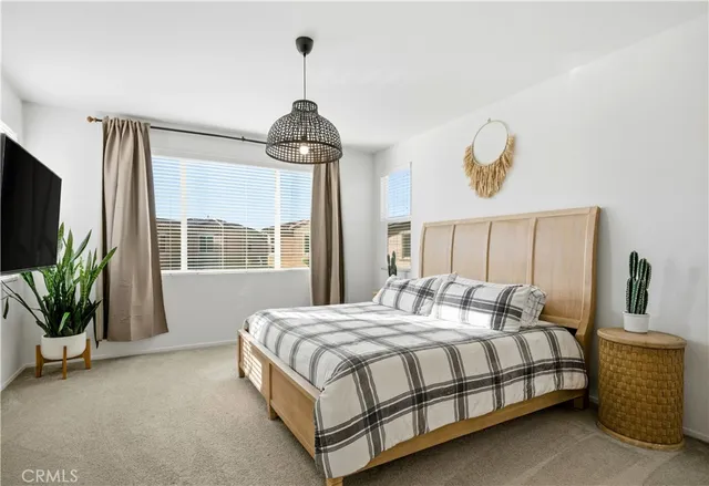 a bedroom with a bed and a chandelier