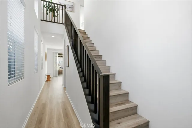 a view of staircase with railing and white walls