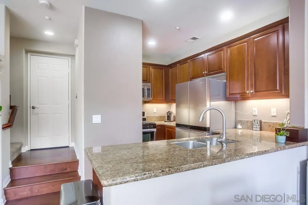 4115 Karst Road Carlsbad, CA 92010 - Photo 11 of 43 a kitchen with stainless steel appliances granite countertop a sink refrigerator and cabinets