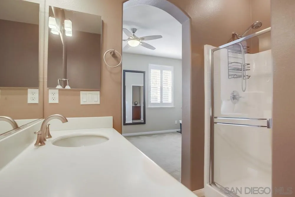 4115 Karst Road Carlsbad, CA 92010 - Photo 26 of 43 a en suite bathroom with a sink a mirror and a shower