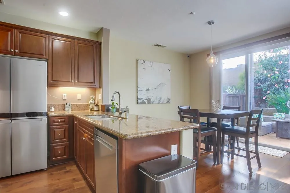 4115 Karst Road Carlsbad, CA 92010 - Photo 6 of 43 a kitchen with a sink a stove a refrigerator a dining table and chairs