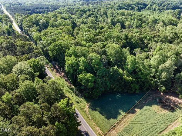an aerial view of residential houses with outdoor space and trees
