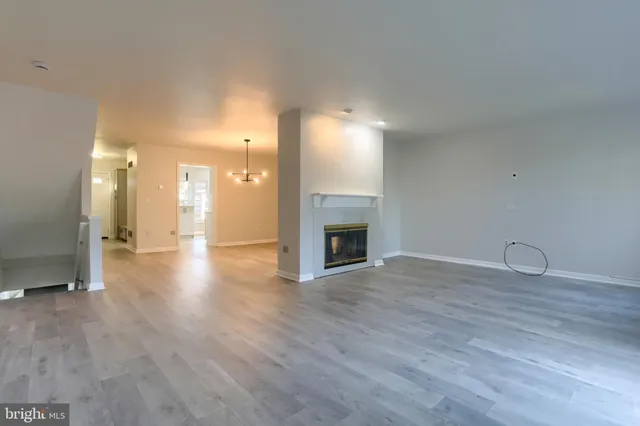 a view of a livingroom with wooden floor and a fireplace