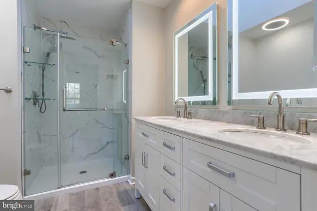 a bathroom with a granite countertop sink mirror and shower