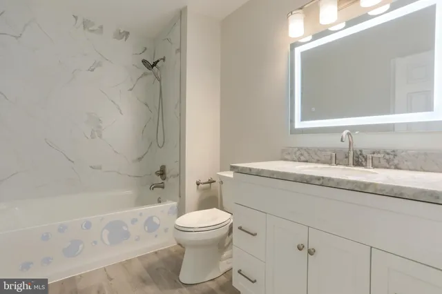 a bathroom with a granite countertop sink toilet and shower