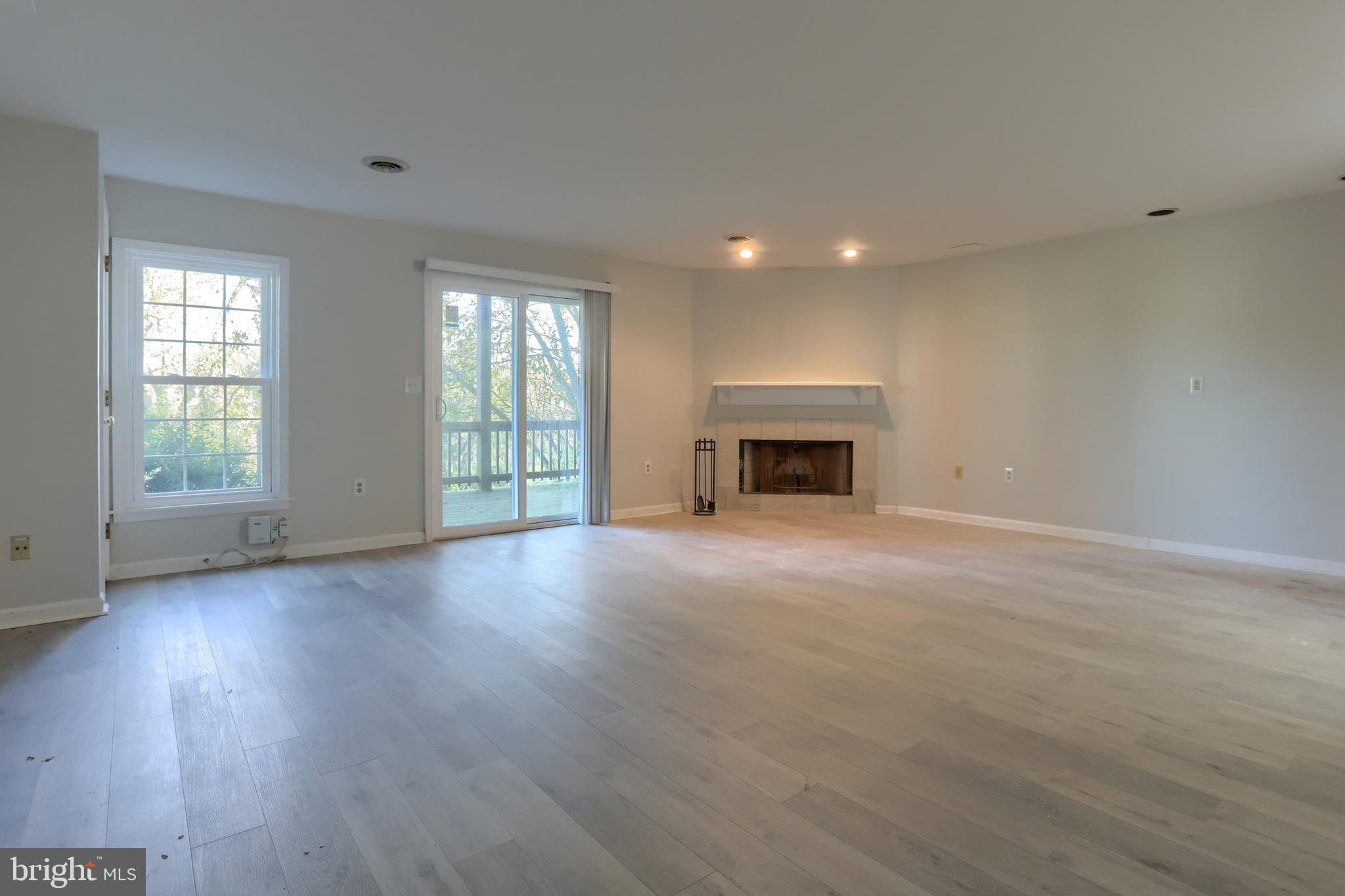 2065 Raleigh Road, Unit B Hummelstown, PA 17036 - Photo 32 of 40 an empty room with wooden floor fireplace and windows