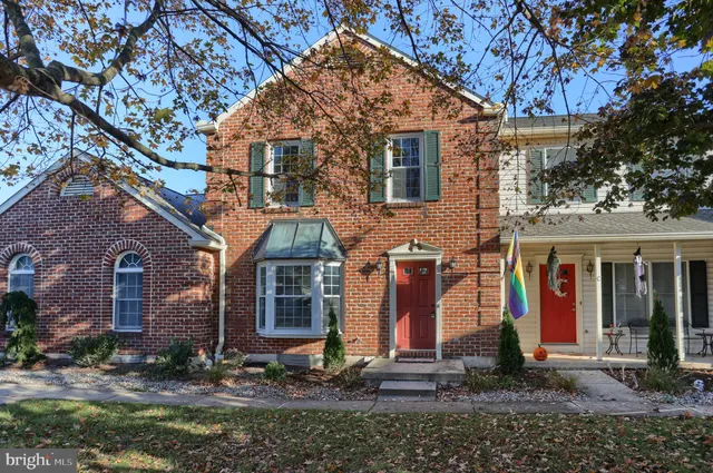 a view of a white house with large windows next to a road