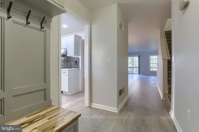 a view of a hallway with bathroom and a glass door