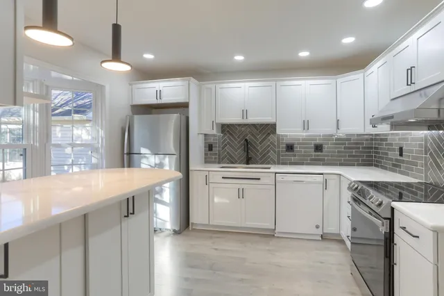 a kitchen with kitchen island granite countertop appliances cabinets and a sink