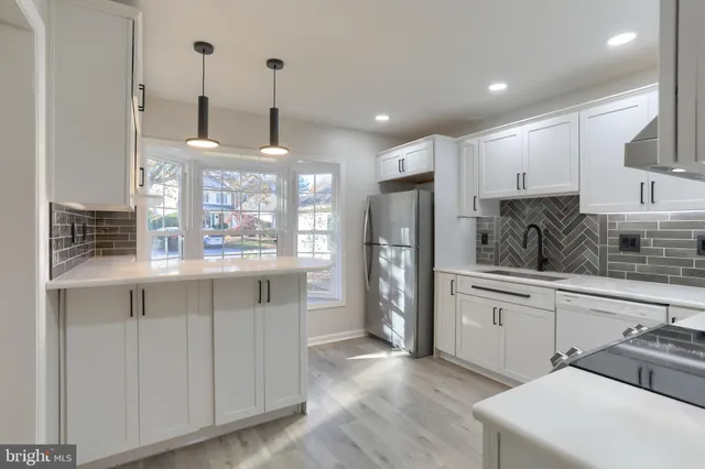 a kitchen with white cabinets and refrigerator