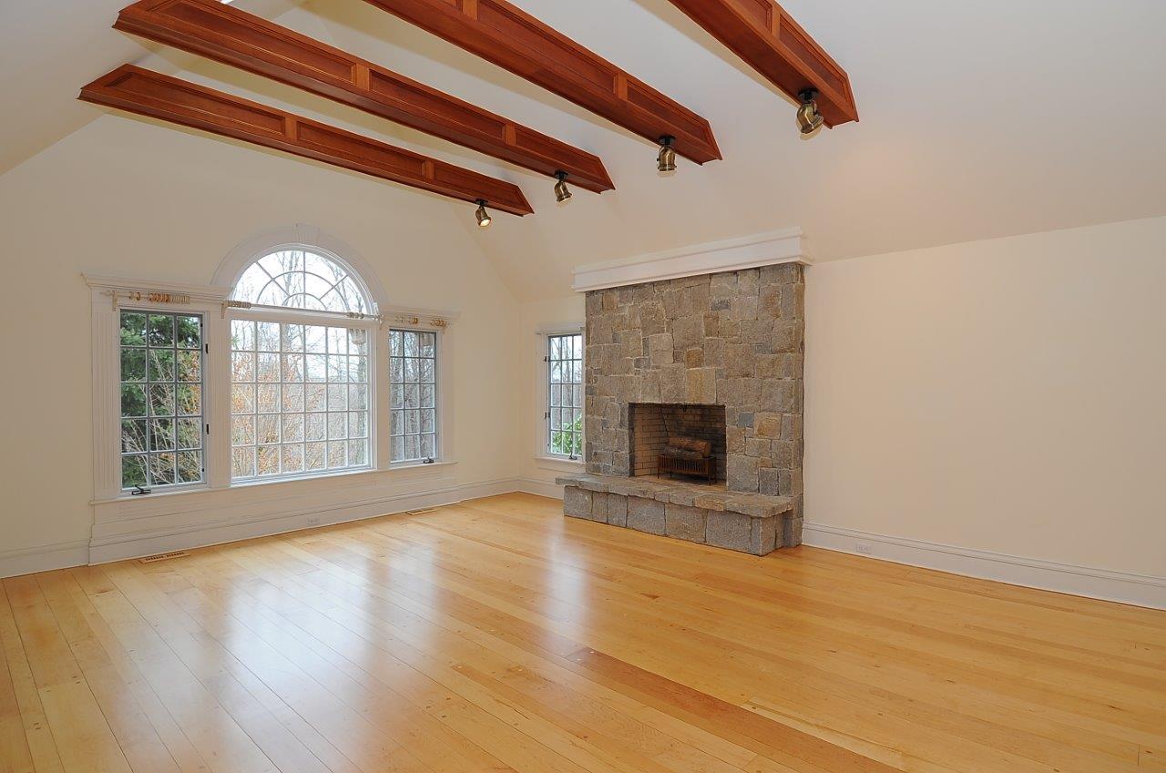 1185 Smith Ridge Road New Canaan, CT 06840 - Photo 5 of 17 a view of an empty room with wooden floor fireplace and a window