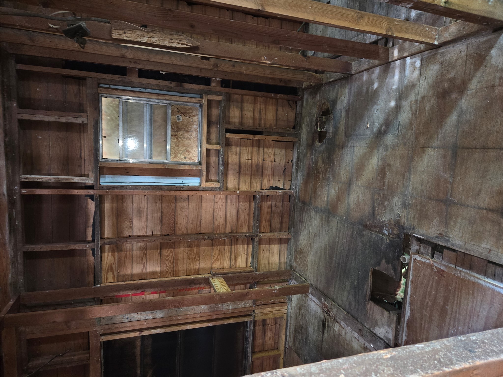 7306 Bethune Avenue Austin, TX 78752 - Photo 11 of 12 A room undergoing significant renovation, with exposed wood framing and subflooring, awaits a complete transformation.