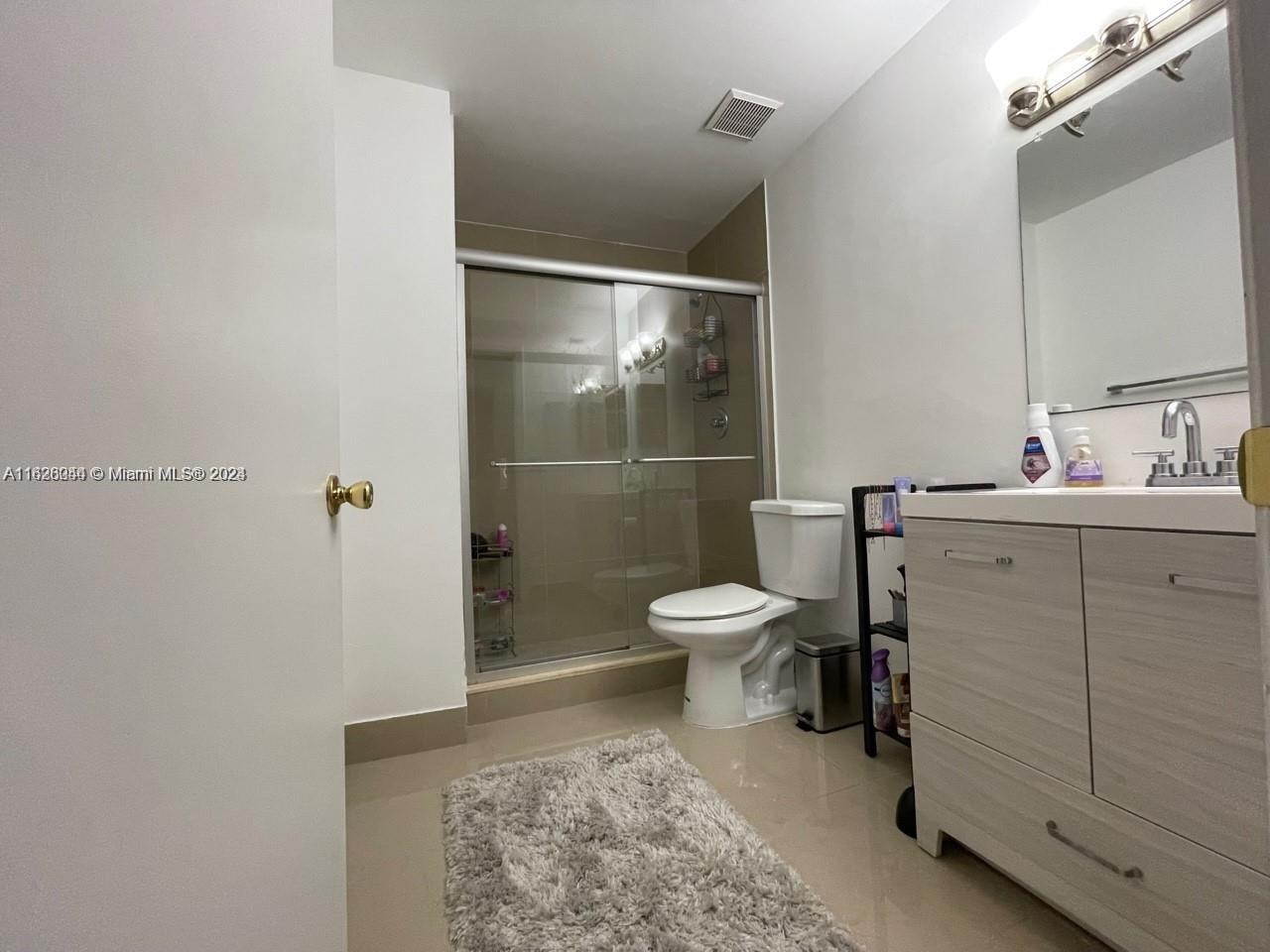 501 Racquet Club Road, Unit 63 Weston, FL 33326 - Photo 13 of 14 a bathroom with a toilet a sink and shower