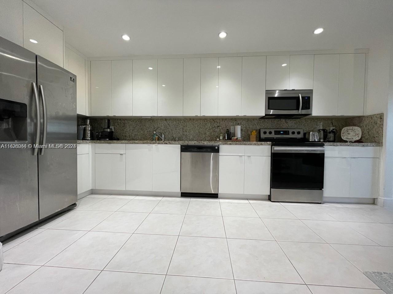 501 Racquet Club Road, Unit 63 Weston, FL 33326 - Photo 3 of 14 a kitchen with stainless steel appliances a stove a sink a microwave and a refrigerator