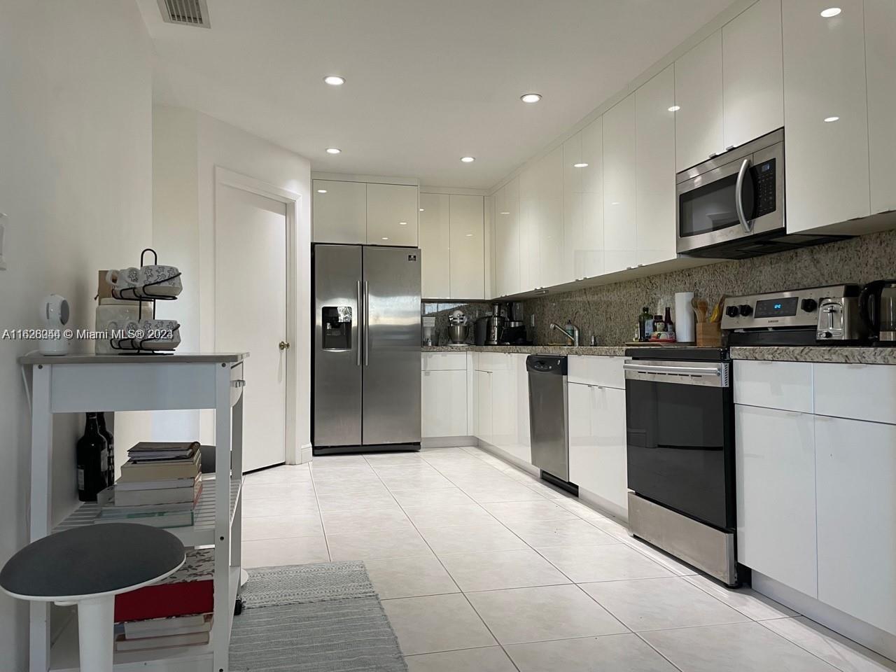 501 Racquet Club Road, Unit 63 Weston, FL 33326 - Photo 4 of 14 a kitchen with kitchen island granite countertop stainless steel appliances and view living room