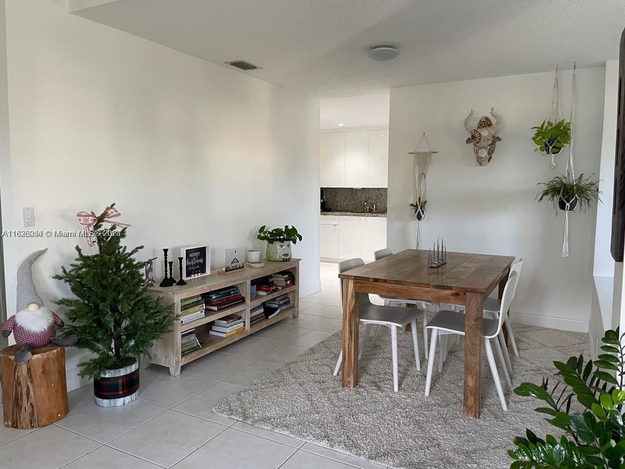 501 Racquet Club Road, Unit 63 Weston, FL 33326 - Photo 5 of 14 a living room with furniture potted plant and a table