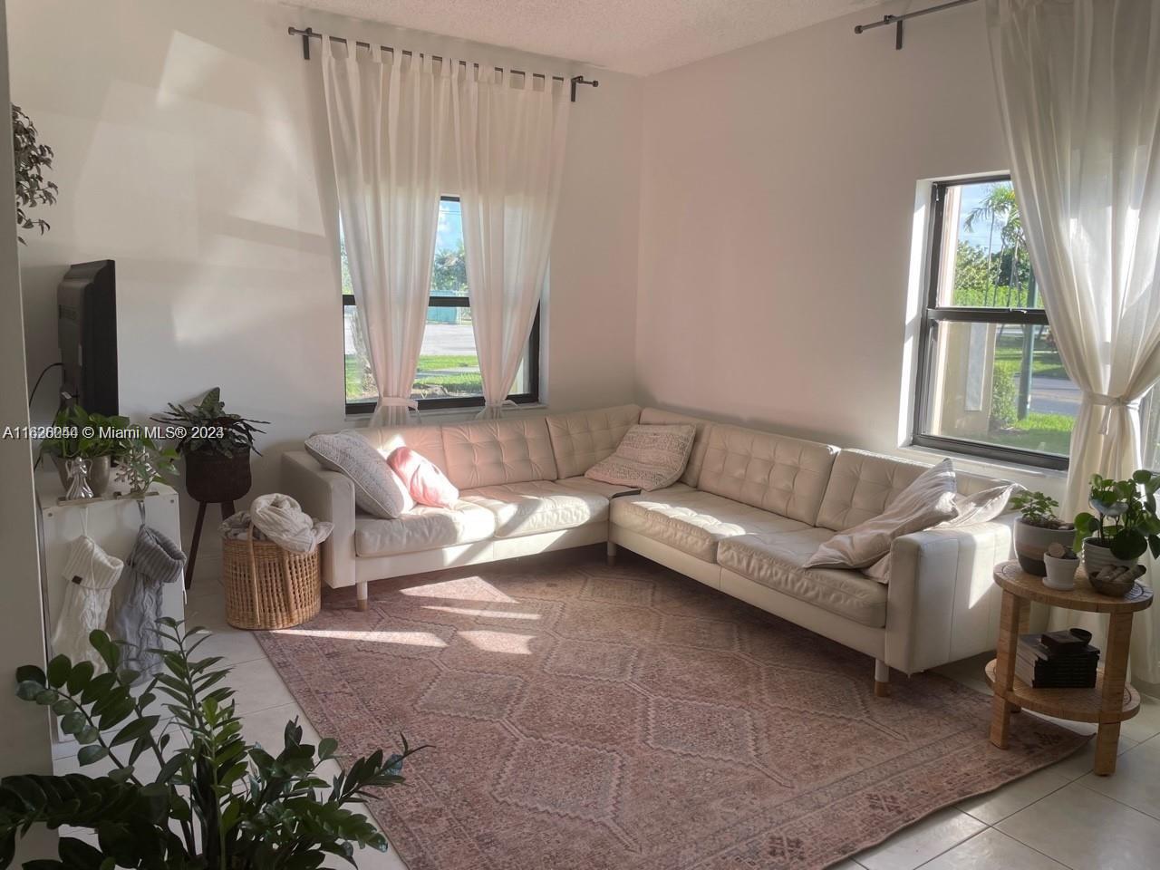 501 Racquet Club Road, Unit 63 Weston, FL 33326 - Photo 7 of 14 a living room with furniture and a flat screen tv