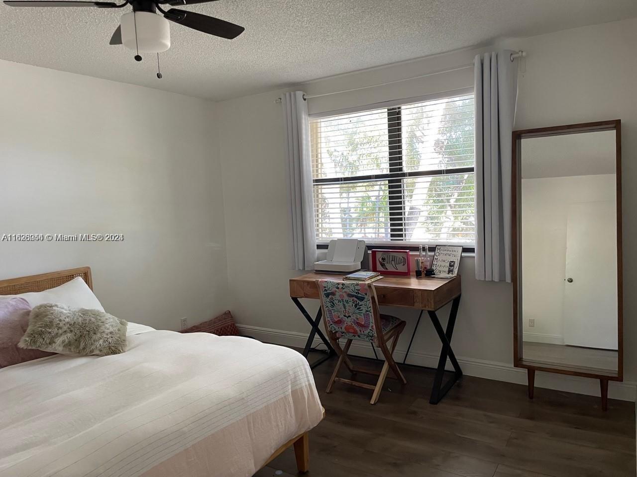 501 Racquet Club Road, Unit 63 Weston, FL 33326 - Photo 10 of 14 a bedroom that has a bed and a table in it