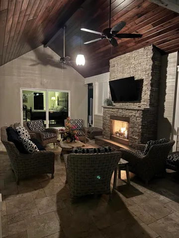 a living room with furniture a flat screen tv and a fireplace
