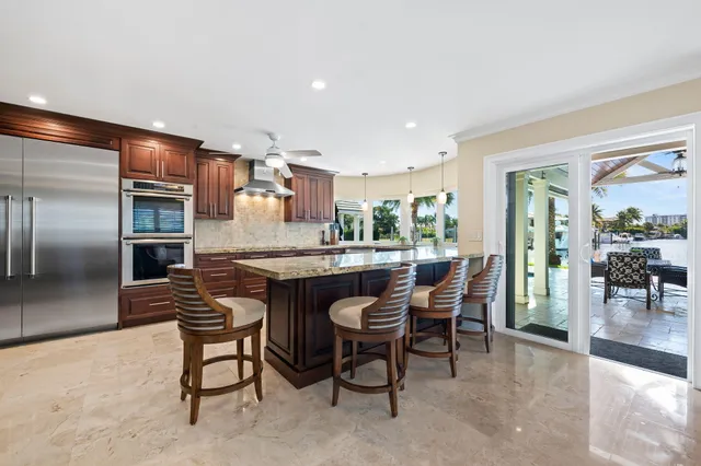 a kitchen with stainless steel appliances kitchen island granite countertop a refrigerator and cabinets
