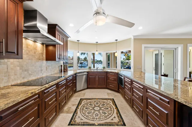 a large kitchen with stainless steel appliances granite countertop a lot of counter space and a sink