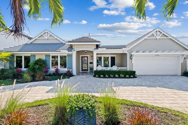 a front view of a house with a yard and potted plants