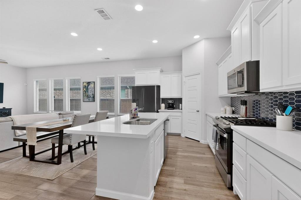 2319 Kirkstall Way Forney, TX 75126 - Photo 12 of 29 a kitchen with stainless steel appliances kitchen island granite countertop a sink and cabinets