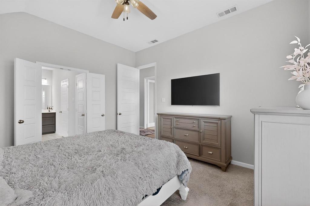 2319 Kirkstall Way Forney, TX 75126 - Photo 13 of 29 a bedroom with a bed and a flat screen tv