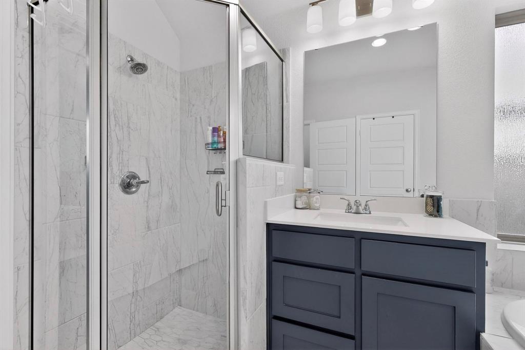 2319 Kirkstall Way Forney, TX 75126 - Photo 15 of 29 a bathroom with a double vanity sink a mirror and shower