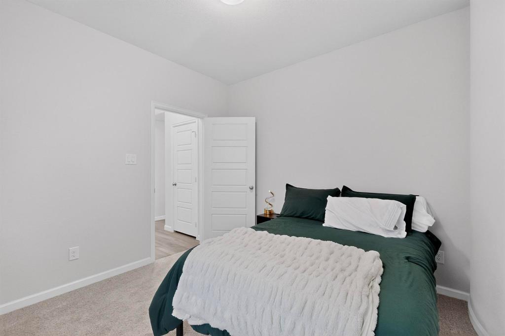 2319 Kirkstall Way Forney, TX 75126 - Photo 18 of 29 a bedroom with a bed and wooden floor