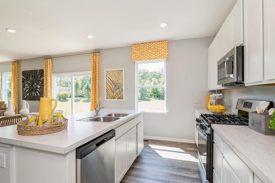 11290 Green Place Winfield, IN 46307 - Photo 16 of 27 a kitchen with stainless steel appliances granite countertop a sink a stove and a refrigerator