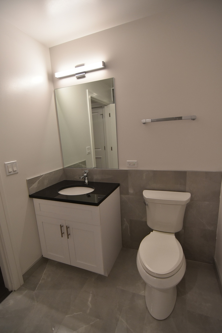 1730 West Greenleaf Avenue, Unit 102 Chicago, IL 60626 - Photo 13 of 15 a bathroom with a toilet sink and mirror
