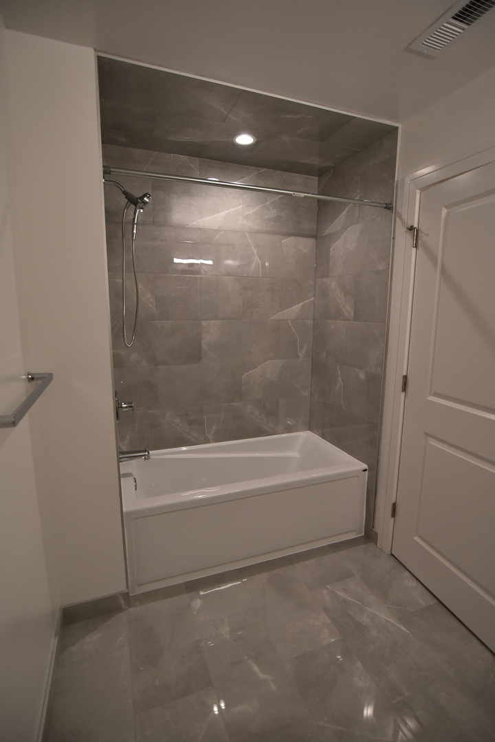1730 West Greenleaf Avenue, Unit 102 Chicago, IL 60626 - Photo 14 of 15 a bathroom with a bathtub and a shower