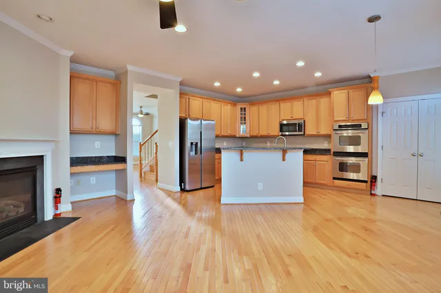 a kitchen with stainless steel appliances granite countertop a refrigerator and a stove top oven