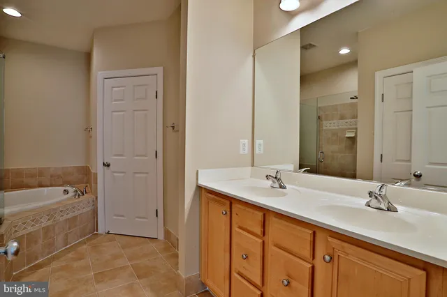 a spacious bathroom with a tub sink and mirror