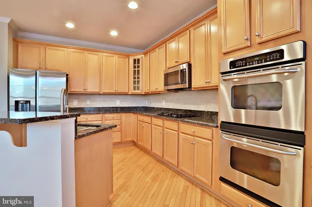 a kitchen with stainless steel appliances granite countertop a stove a microwave and a sink