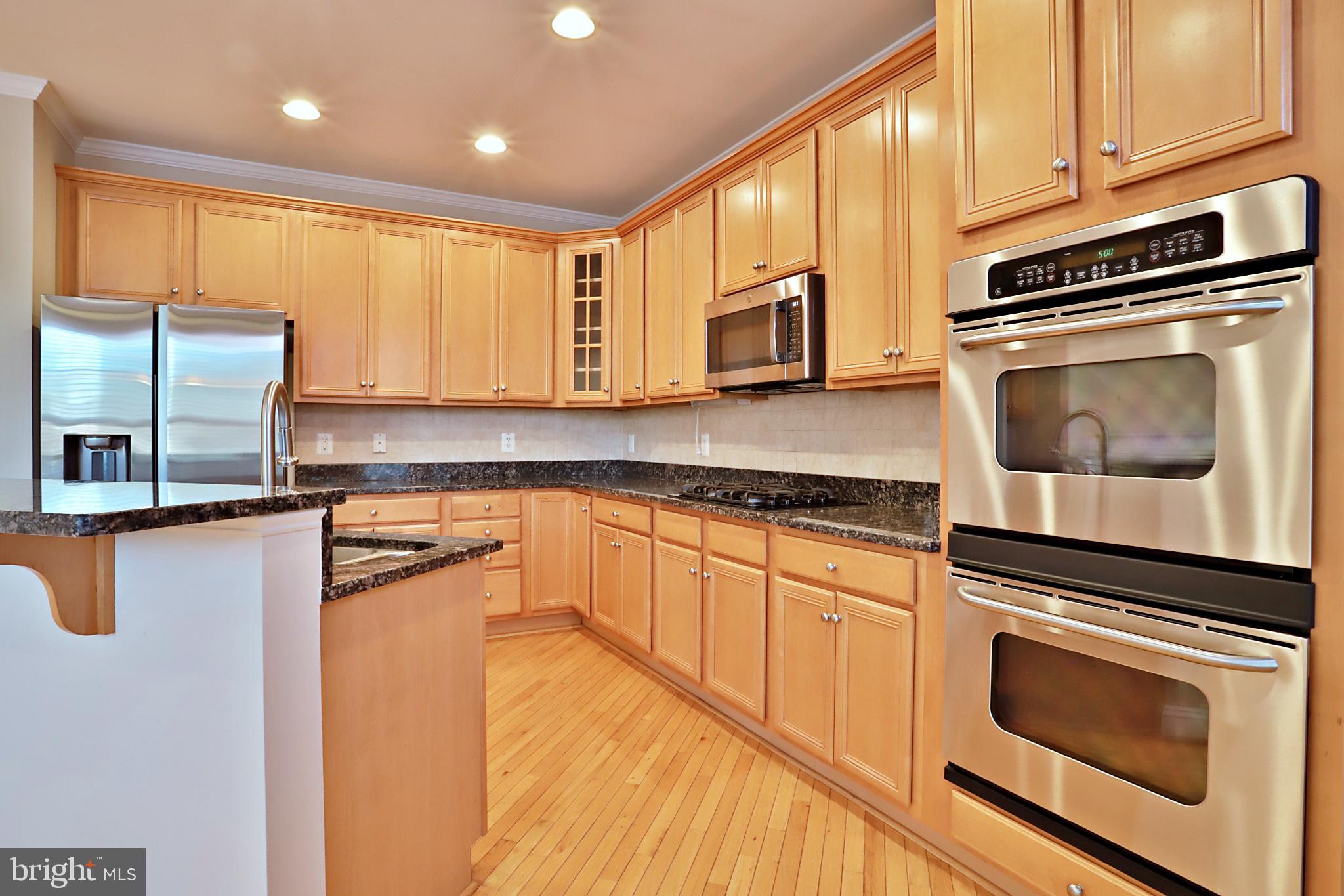 135 Fortnightly Boulevard Herndon, VA 20170 - Photo 3 of 29 a kitchen with stainless steel appliances granite countertop a stove a microwave and a sink