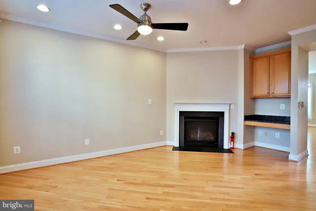 a view of an empty room with a fireplace and a window
