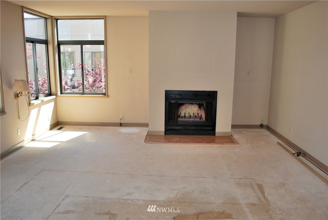 2021 1st Avenue, Unit 55 Seattle, WA 98121 - Photo 11 of 20 a view of an empty room with a fireplace and a window