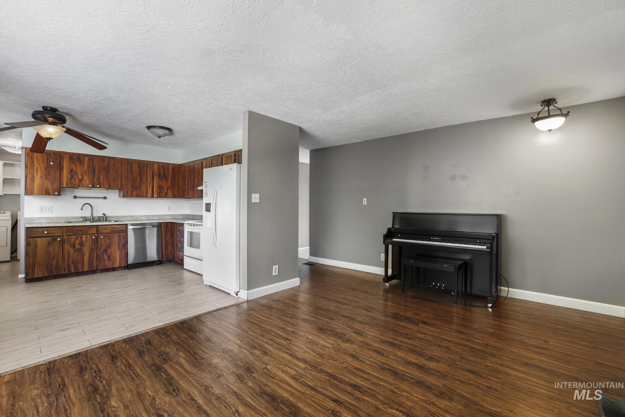 712 Locust Street Kimberly, ID 83341 - Photo 8 of 26 Spacious room featuring wood-finish flooring, white baseboards, and a neutral wall palette