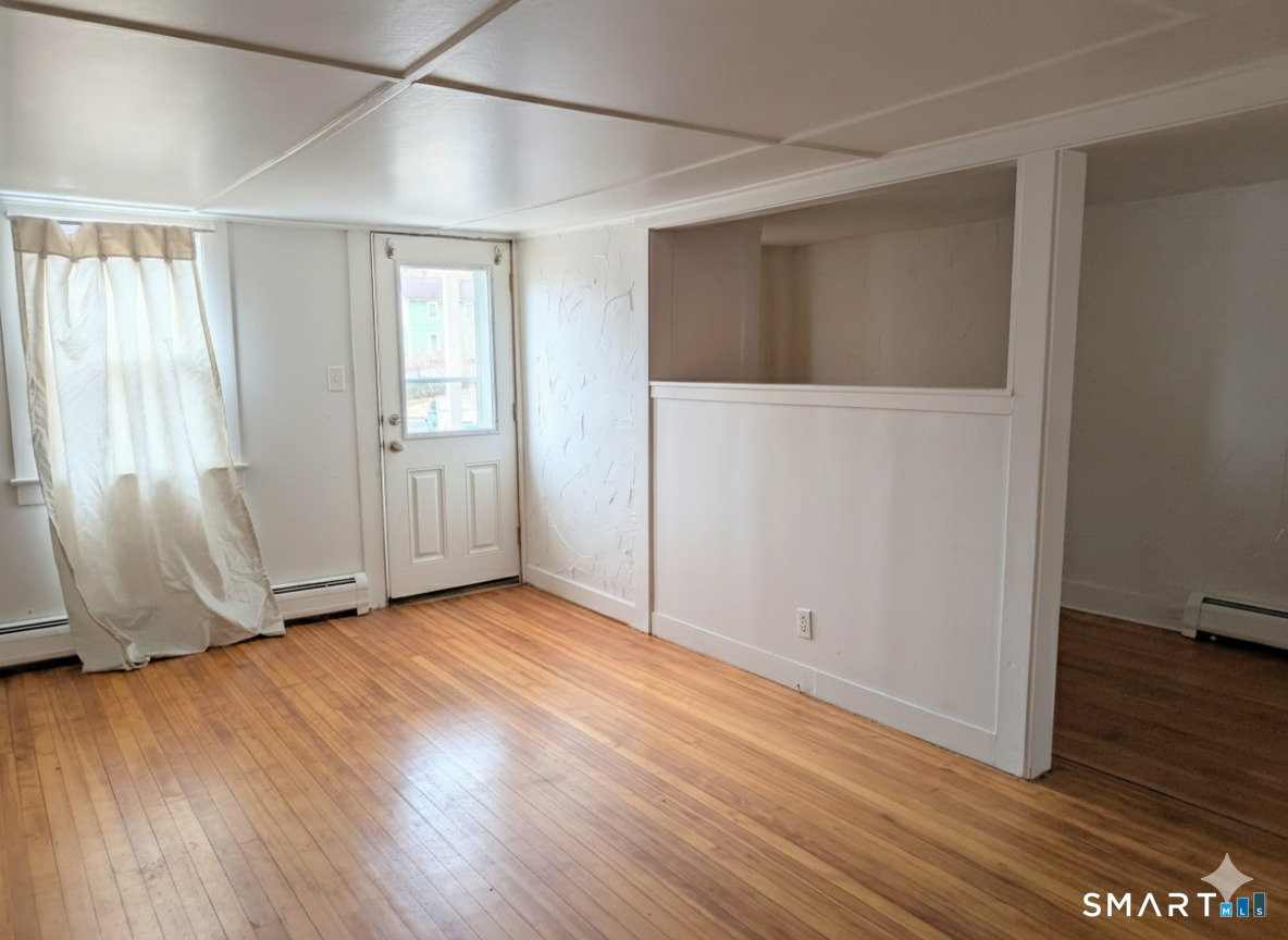 71 Bridge Street Canton, CT 06019 - Photo 2 of 6 an empty room with wooden floor and windows