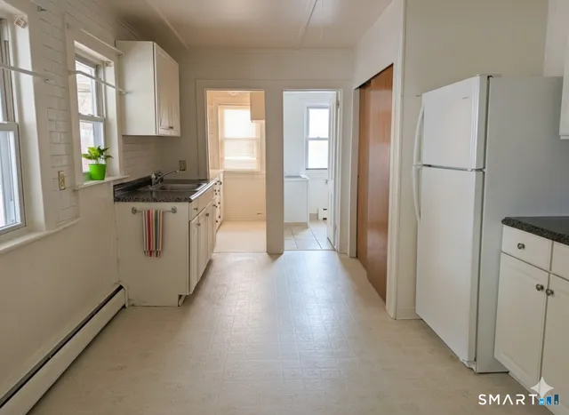 a kitchen with stainless steel appliances a refrigerator a stove a sink and a window