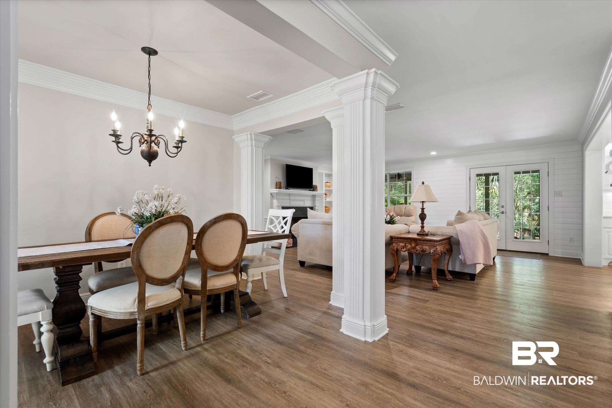 3715 Latigo Road Mobile, AL 36695 - Photo 3 of 39 Dining area featuring ornate columns, wood finished floors, crown molding, and a chandelier