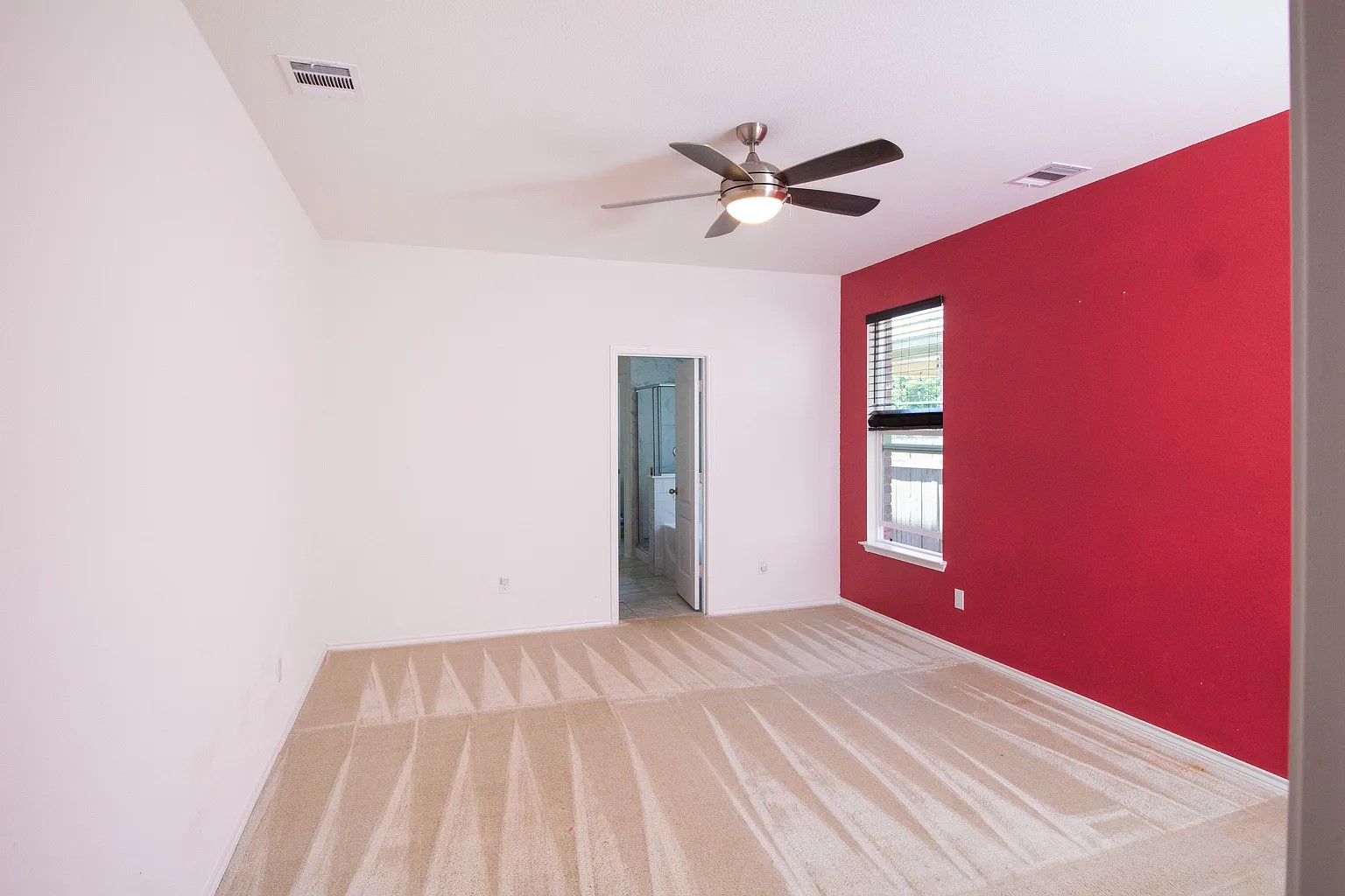 17403 Headstock Road Round Rock, TX 78664 - Photo 4 of 16 A well-lit bedroom features plush carpet and a convenient ceiling fan for optimal comfort.