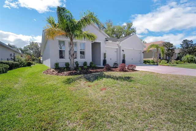 a living room with furniture a chandelier fan and a large window